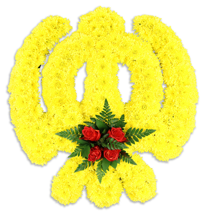 This meticulously fashioned floral Khanda is presented on a clean white field, an emblem of Sikh identity rendered entirely in flowers and texture. The overall silhouette - the circular chakram enclosing the central double-edged khanda and the crossed kirpans below - is built from thousands of tiny yellow chrysanthemum blooms, each packed closely so the surface reads like a warm, tactile carpet of petals. The yellow is bright and confident, the chrysanthemums' many layered petals catching the light and casting delicate highlights across the symbol's curves, evoking the gentle morning glow over Brunswick Park and the quieter lanes off Barnet High Street. Nestled precisely at the emblem's centre, a compact bouquet of deep red roses - five tightly grouped buds - anchors the design; they are encircled by deep green fern fronds whose fine, lacy leaves add shadow, rhythm, and depth against the luminous yellow. The arrangement sits slightly raised from the white background, a soft grey shadow beneath giving it volume and the sense of a handcrafted memorial piece ready for placement at a service or cultural observance. The scent is understated but present: a fresh green note from the chrysanthemums with the deeper rose perfume layered above, together creating an atmosphere of calm and respect. As a floral statement, it balances symbolism and sensitivity - perfect for ceremonies honouring Sikh heritage, remembrance gatherings, or community tributes held in and around New Barnet and neighbouring suburbs.