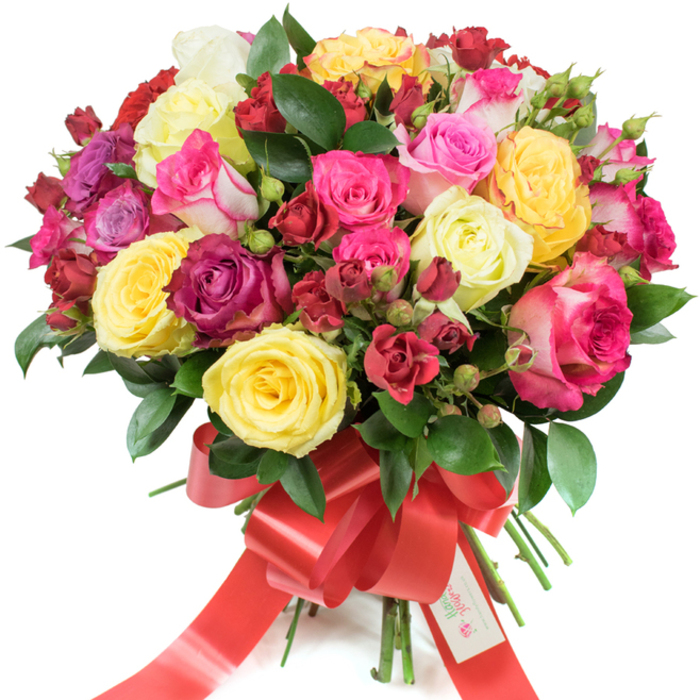 A sumptuous, meticulously assembled hand-tied bouquet of premium roses set against a clean white background, the kind we prepare at Flowers New Barnet for same-day delivery across New Barnet and nearby Oakleigh Park. The arrangement reads as rich and celebratory: bright yellow roses that lift the mood, soft creamy-white blooms for calm, and a layered spectrum of pinks ranging from pastel blush to bold fuchsia, with some petals edged in contrasting lighter tones. Deep red and burgundy roses create dramatic pockets of intensity, while smaller spray roses and tight, button-like buds add texture and promise of further opening. Interspersed throughout are glossy, dark-green leaves - ruscus or salal - whose lustre makes the colours sing and gives the bouquet a lush backdrop. The stems are gathered tightly and finished with a wide, festive red satin ribbon knotted into a prominent bow with long, flowing tails; a small white tag tucked into the ribbon bearing the words 'Happy Holidays' gives a seasonal, thoughtful touch. Under soft directional light the petals show velvety depth and delicate veining, and the composition suggests movement as blooms spiral outward from the centre. The scent is clean and slightly citrus-laced, fresh as a morning walk through Brunswick Park, and the overall impression is one of warmth, celebration, and considered craftsmanship - a perfect floral gift for birthdays, anniversaries, Valentine's Day, Mother's Day, or to send heartfelt appreciation around the neighbourhood.