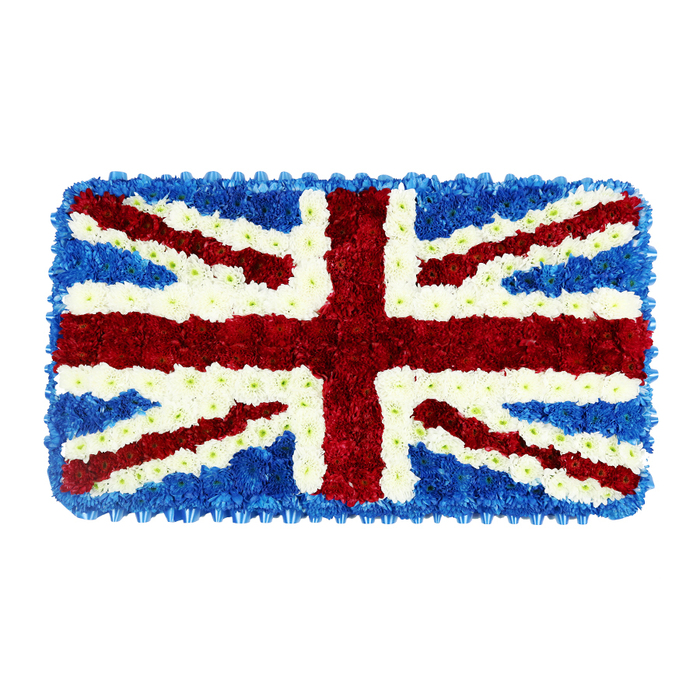A beautifully structured funeral tribute in the exact shape and pattern of the Union Jack flag fills the frame, created from thousands of fresh flowers in intense red, snowy white, and deep blue shades. Set against a clean white studio-style background, the arrangement stands out clearly, allowing every detail of the design to be appreciated. The base of the piece is a sea of dark blue blooms, likely small-headed hydrangeas or similar tightly clustered flowers, which provide a uniform backdrop and a neat border around the rectangular edge. On this blue field, the broad red St. George's Cross dominates the centre, running vertically and horizontally with unwavering straight lines. These red stripes are expertly shaped from small, rounded blossoms, their dense placement giving the tribute a soft, cushioned depth. Radiating diagonally from each corner are the slimmer red bands of St. Patrick's Cross, each one carefully aligned and balanced so that the geometry of the flag remains accurate. Surrounding and separating these red crosses are bright white flowers, forming both the broader diagonal arms of St. Andrew's Cross and the finer white outlines that keep the colours distinct. The interplay of the three shades, combined with the natural texture of the petals, turns this flat flag design into something almost sculptural. In New Barnet, such a patriotic floral piece would often be chosen for a funeral or memorial with a strong British theme, perhaps for someone who served in the armed forces or who had a deep love for their country. Florists familiar with the area's churches, crematoria, and local traditions would ensure that this Union Jack tribute travels safely from the workshop to a New Barnet service, where it can stand as a respectful symbol of pride, remembrance, and enduring connection.