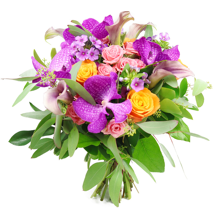 A sumptuous, full-bodied bouquet appears almost to float against its clean white background, every colour and curve carefully composed like a piece of floral art inspired by the quiet elegance of New Barnet's leafy streets. In the centre, the most striking elements are the exotic Vanda orchids, their large, flat petals drenched in jewel-like shades of fuchsia-purple and patterned with intricate speckles, giving them a dramatic, almost velvety presence. Interwoven with these orchids are bright tangerine-orange roses, their compact, spiralled blooms adding a lively, uplifting energy, while clusters of blush and pastel pink roses bring a softer, romantic note, some blooms still in tight bud form and others gently unfolding to reveal many delicate layers. Rising slightly above the rounded mass of blossoms, tall calla lilies in a gentle blend of plum, mauve, and dusty lavender add graceful lines; their smooth, trumpet-shaped flowers curve with quiet confidence, lending the bouquet a refined, modern silhouette. Around the flowers, a base of lush greenery forms a deep, verdant cushion: slender, silvery eucalyptus stems create a cool, airy frame, while broader, darker leaves provide structure and contrast. Tiny lavender and lilac filler flowers, along with fine green sprigs, weave in and out of the larger blooms, adding shimmer and intricate texture, as though gathered from a well-tended garden near Victoria Park. The cut stems are clearly visible at the base, bound together in a classic hand-tied style that speaks to professional craftsmanship. Overall, the bouquet conveys indulgence and heartfelt sentiment, an ideal choice for marking life's important moments in EN5, from intimate dinners at home to celebratory gatherings in New Barnet.