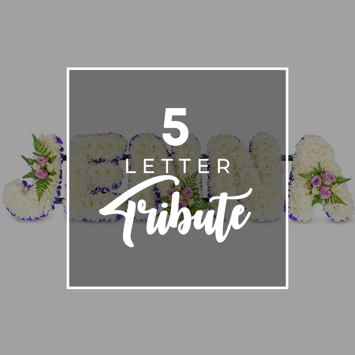 In this photograph, a bespoke five-letter floral tribute for a funeral or memorial is displayed in a careful, horizontal line against a pale grey backdrop, the simplicity of the background drawing full attention to the intricate flower work. The letters themselves are large and robust, yet they appear soft and tender thanks to the dense layer of pure white chrysanthemums or carnations that completely covers each form. Every blossom is placed closely beside the next, creating a continuous, textured blanket of petals that suggests purity, peace, and a gentle farewell. Around the outer edges of the letters runs a defined border of deep purple satin ribbon, adding structure and contrast, its rich tone giving the tribute a refined, respectful presence that would sit beautifully in a chapel of rest or at a New Barnet crematorium chapel. Here and there, at thoughtful points around the shapes, the florist has added small clusters of accent flowers: pale pink and mauve spray roses, their buds at varying stages of opening, mingling with fine fern fronds and glossy green foliage tips. These touches introduce soft colour and natural movement, like small garden posies placed lovingly by hand. Over the centre of the arrangement is a square of semi-transparent grey, slightly darker than the background and edged with a neat white border. On this panel, white text reads 5 LETTER in clean, uppercase type above the more flowing word Tribute, clearly indicating that the display can be adapted to any five-letter name or word. The overall impression is one of tailored remembrance and quiet beauty, the sort of floral lettering a family in New Barnet might choose to honour a loved one's name with sincerity and grace.