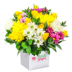 In this detailed studio image, a rounded, densely packed bouquet of mixed flowers sits confidently in a neat white cube-shaped box, positioned against a completely white backdrop so every tone and texture is easy to imagine. The arrangement has the lively energy of a spring morning in New Barnet, its colour palette led by rich yellows and softened by whites and jewel-like magenta accents. Multiple yellow roses, some tightly furled and others just starting to unfurl, cluster together alongside large yellow chrysanthemums whose plush, many-petalled heads create a cushion of sunshine at the heart of the design. Between them, bright white daisy chrysanthemums with distinct green eyes peek out, their slim petals radiating neatly around each centre, while fuller white chrysanthemums lend extra depth, their soft, feathery petals overlapping to form generous domes. Weaving throughout, bold fuchsia and magenta chrysanthemums introduce a vivid contrast, their layered petals sometimes tinged with lighter pink, giving a subtle ombré effect that feels playful yet refined. Small pink and extra yellow rosebuds are tucked here and there, suggesting new blooms about to open and adding to the sense of life and movement. Around the base and between the flowers, glossy dark green foliage, likely ruscus or similar hardy greenery, anchors the composition, its broad leaves creating a cool, natural backdrop for the brighter colours. The modern white box keeps the look clean and contemporary, reminiscent of chic gift packaging you might carry along the High Road towards New Barnet station. Overall, the bouquet gives an impression of warmth, optimism, and celebration, ideal for same-day flower delivery to mark birthdays, congratulations, or thoughtful pick-me-up moments across New Barnet.