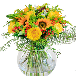 This radiant bouquet, crafted with care by florists in New Barnet, celebrates the essence of late summertime within the community. Towering sunflowers with golden-yellow petals open wide like rays of sunshine, anchoring the display with their signature brown centers that seem to smile at every glance. Nestled closely are rich yellow garden roses, each bloom unfurling its velvety spirals in a gentle crescendo that evokes the welcoming spirit of local mornings. Contrasting with the warmth of the sun and roses, clusters of scarlet Hypericum berries are peppered throughout, lending a playful, jewel-like brightness that catches the eye-much like berries spotted along woodland paths in Oak Hill Park. The bouquet brims with a tapestry of greenery: feathery fern fronds spill outwards, goldenrod and wispy fillers soften the ensemble, and eucalyptus leaves offer subtle, cool relief both visually and in scent. All elements gather within a luminous, round glass vase, where the clarity reveals the complexity and polish of each stem as they intertwine underwater. The overall effect is one of unrestrained optimism-perfect for milestones, heartfelt congratulations, or simply brightening someone's day with a touch of New Barnet's natural charm. Whether for delivery to a friend in High Barnet or as a refreshing splash of colour on a local kitchen table, this arrangement embodies the best of seasonal beauty and local craftsmanship.