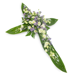 Viewed from a slightly overhead perspective against stark white, this floral cross presents a composed study in serenity and texture. The bold framework is constructed from large, glossy green leaves, layered with care to form the arms and central axis of the cross; their reflective surfaces and prominent veins create a living, verdant backdrop. Crowding the intersection and extending outward are clusters of soft, creamy lisianthus whose ruffled petals fold inward like gentle whispers, alongside compact white chrysanthemum or miniature rose-like blossoms that bring clarity and light. Sprays of tiny lavender-hued asters or limonium thread through the white, offering a cool contrast and a sense of depth, while slender sprigs of fine green filler nestle between blooms to lift and separate them visually. The overall palette - deep green, creamy white and pale purple - reads as peaceful and restrained, the kind of composition chosen to convey respect and consolation at a funeral service or memorial table. The even, soft studio light removes visual noise and accentuates the delicate petal edges and the waxy sheen of the foliage; one can almost sense a faint, green floral aroma, subtle and calming. As a local florist's composition, it suits services and remembrance gatherings across New Barnet, from small parish chapels to quiet commemorations near Station Road and Brunswick Park, offering a tasteful, comforting expression of condolence.