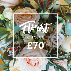 An intimate, overhead study of a florist's signature arrangement: large, luxurious roses in blush pink, creamy white and soft peach take center stage, complemented by a handful of muted lavender-rose blooms that lend a dusty, romantic counterpoint. Tiny, ethereal white filler flowers and delicate pink-tinged berries peek through the main blooms, while feathery, cream-to-tan dried elements-think slender grasses and seed clusters-introduce a rustic, textural softness that pools around the stems. Broad, rounded eucalyptus leaves in their characteristic dusty blue-green slip between the roses, giving a cool, structured backdrop and a faintly aromatic lift to the composition. Sunlight skims across petals and leaves, accentuating the gentle curves and whisper-thin textures, producing a mood of calm refinement.

Superimposed in the heart of the photograph is a clean, white rectangular frame bearing the words "Florist Choice" in a flowing script, with "CHOICE" set in an understated uppercase sans-serif directly beneath it, and the price clearly marked as "?70" in bold numerals at the bottom. The graphic sits lightly on the bouquet, signaling a considered, expert selection without obscuring the floral detail.

As a local florist might suggest while walking near Monken Hadley Common or dropping a delivery off around Oakleigh Park, this bouquet feels made for intimate celebrations-a thoughtful Mother's Day surprise, a small wedding bouquet alternative, or an anniversary gift. The overall effect is romantic, tactile and handcrafted, promising both freshness and the quiet confidence of an experienced designer who knows New Barnet well.
