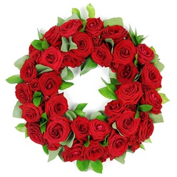 Carried by the dedicated team at Flowers New Barnet, this wreath of red roses feels almost ceremonial, as if each petal is woven with heartfelt care and reflection. The ring is densely packed with dozens of deep crimson blooms, their velvet petals catching soft light and revealing subtle variations in shade. Fresh, verdant foliage peeks through in gentle crescents-broad, matte greens echoing eucalyptus and sleeker, glossy ruscus-creating a tranquil contrast that lets the red tones glow. The circular form remains perfectly unbroken, a symbol of eternal connection and quiet remembrance, while the overall impression is one of fullness and dignified abundance. The scent of rose lingers in memory even from a still image, inviting the senses to pause and breathe.

The arrangement is deliberately composed to carry a message of sympathy and consolation, appropriate for funerals, memorial services, or anniversaries of a beloved life. The backdrop is a crisp white, rendering the bouquet pristine and focused, so the eye travels from the velvet petals to the delicate greens and back again. For readers seeking familiar London-area relevance, this wreath speaks to the artistry of heartfelt tribute found in New Barnet and the surrounding EN4 communities, where family, friends, and neighbours come together to honor a life well loved. Flower New Barnet offers reliable service across the local area, with a promise of careful preparation and careful delivery.

From our workshop near New Barnet High Street to your doorstep, this red rose wreath embodies enduring love and steadfast remembrance, a timeless gesture that endures beyond the moment and offers solace in sorrow.
