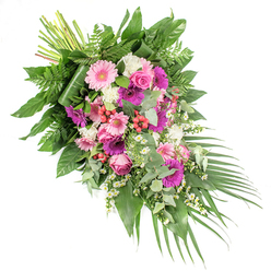 Displayed against a bright white background, this hand-crafted funeral spray forms a graceful diagonal from the bundled stems at the upper left to the softly tapering foliage at the lower right. It is a lush, flowing tribute that feels at home in the calm, tree-lined avenues of New Barnet, created to bring a sense of comfort to a chapel or crematorium service. At the heart of the design, open-faced gerbera daisies in soft baby pink, vibrant fuchsia, and deep magenta catch the eye, each bloom radiating a gentle cheerfulness amid the sorrow. Nestled among them are elegant pink roses, their tightly furled petals suggesting devotion and enduring love. Between these larger flowers, clusters of ruffled white blossoms-likely carnations or mini chrysanthemums-add a delicate brightness, softening the stronger tones and drawing the gaze along the length of the spray. Scattered throughout, tiny white daisy-like filler flowers echo the look of wild chamomile and bring a light, almost playful texture, as if a breeze had threaded them gently through the arrangement. Bright red hypericum berries sit like glistening beads among the petals, adding a subtle yet striking note of colour. The blooms are supported by a rich base of greenery: glossy dark leaves provide structure, feathery ferns lend natural softness, and rounded, silvery eucalyptus leaves introduce a modern, calming touch and a hint of fresh scent. From the lower right, long palm fronds extend outward in an elegant arc, emphasising the cascading motion. This dignified floral spray is suited to funeral services, wakes, or celebrations of life in and around New Barnet, offering a thoughtful expression of sympathy, remembrance, and quiet hope.
