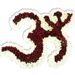 There is immediate artistry and devotional care in every curve of this Om-shaped floral tribute, photographed against a clean white background that lets the symbol breathe. The central '3'-like sweep and its attached strokes are tightly formed from deep red-maroon chrysanthemums whose tiny lime-green centres peek through like subtle accents, creating a rich, velvety mass. A thick, undulating outline of immaculate white spray chrysanthemums frames the whole symbol, defining negative spaces and lending luminous contrast that makes the iconography unmistakable. The arrangement's dense packing and layered petals give a sculptural, tactile quality - the blooms would feel cool and silky to the touch - while a faint, earthy floral scent suggests careful selection of fully fresh stems. A delicate drop shadow anchors the piece, hinting at its three-dimensional construction on a foam or wired base. As a florist who prepares tributes for community events and quiet remembrance across New Barnet - from Station Road to Monken Hadley Common - I picture this piece at a memorial, a cultural celebration, or a yoga and meditation gathering where the Om symbol is both devotion and design. Flowers New Barnet crafts pieces like this with precision and respect; the overall mood is serene, solemn, and quietly hopeful, offering a focused emblem for prayer, chanting, or contemplative ceremony close to home.