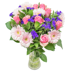 Arranged with care by your trusted New Barnet florist, this radiant bouquet balances soft pastels with vibrant notes, evoking the optimism of spring along East Barnet Road. Velvety blush gerbera daisies mingle gracefully alongside classic pink roses, their spiraled petals unfurling as if bathed in gentle sunlight peeking through neighborhood windows. Splashes of deep purple statice lend lively punctuation, their papery texture both unique and bold, resembling the bursts of colour found in Hadley Green Park. Anchored by rich green foliage reminiscent of local hedgerows, the bouquet's freshness is tangible, the leaves cool and dewy to the touch. Presented in a clear glass vase, stems and water visible, every detail bears witness to expert craftsmanship and heartfelt intent. Perfect for celebrations, heartfelt wishes, or as a refined accent in a New Barnet living room, this arrangement speaks of joy and thoughtful artistry in every carefully placed bloom.