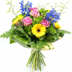 A colourful hand-tied bouquet stands out crisply against a clean white background, the image capturing every petal and leaf with the clarity of fresh flowers just prepared in a New Barnet shop. At the centre, several pink roses are in full, graceful bloom, their petals softly curved and densely layered, creating a romantic focal point that feels both elegant and welcoming. Around them sit bright yellow gerbera daisies, each bloom perfectly round with a deep brown central eye, radiating warmth like tiny sunbursts. These gerberas introduce a playful, optimistic note that would suit a birthday surprise, a congratulations bouquet, or a simple gesture of appreciation sent to a friend near East Barnet Village or along Station Road. Above the rounded shape of the main flowers, slender stems of deep blue delphiniums lift the eye upward, their cool, inky-blue florets forming vertical accents that balance the warmth of the pink and yellow tones.   

The bouquet is densely layered with greenery, giving it a lush, abundant feel. Soft, feathery fern fronds trail from the edges, adding movement and a slightly wild, garden-grown impression, as if the stems were gathered after a peaceful walk through one of New Barnet's green spaces. Larger, glossy dark green leaves sit behind and among the blooms, catching the light with a subtle sheen. Some of these wider leaves are wrapped carefully around the base of the flower heads, creating a structured green collar that holds the bouquet together and highlights the florist's professional touch. Throughout the arrangement, clusters of bright green, textured filler foliage nestle between the larger flowers, making the design appear full and rounded while offering interesting detail when viewed up close.   

Slender green stems topped with small buds reach delicately above the main flowers, suggesting life and growth and adding a whisper of movement. At the bottom of the image, the gathered stems are bound neatly with a simple, natural-toned ribbon or twine, clearly visible and reinforcing the hand-crafted nature of the design. The overall effect is of a joyful, contemporary bouquet ready to be delivered across New Barnet, bringing colour, scent, and a sense of thoughtful care into any home or office.