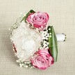 This bouquet, thoughtfully arranged to reflect the tranquil spirit of New Barnet, fills the senses with soft romance and joyful promise. Three pink roses, each meticulously unfurled and brushed with vivid fuchsia fading gently to blush and lilac at the center, nestle amid billowy white peonies-whose countless, ruffled petals conjure visions of early spring along Meadway or near Hadley Wood. Interlaced among the larger blooms are playful wisps of gypsophila, their petite, star-like white blossoms imparting a frothy lightness and ethereal quality. Glossy, deep green leaves wrap around the base, framing the flowers with fresh vibrancy and sculptural poise, their curves reflecting the careful touch of the skilled New Barnet floral team. The stems are expertly tied with an immaculate white satin ribbon, suggesting refinement and thoughtful preparation for a bride, attendant, or cherished recipient. Set against a textured, neutral backdrop-rich in tactile appeal-the arrangement's interplay of color, scent, and structure invites reflection and delight. Gentle natural light amplifies the bouquet's freshness and the subtle intricacies of each petal. Ideal as a bridesmaid's bouquet or romantic gesture, this piece is a heartfelt celebration of beginnings and milestones, woven together with local care and artistry for any special moment in New Barnet.