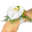 Softly lit against a pristine white backdrop, a delicate wrist corsage rests on a fair-skinned wrist like a quiet promise. The centerpiece is a single, large white Phalaenopsis orchid-its broad, satiny petals unfolding with a gentle symmetry-and at its throat a small, luminous yellow lip tipped with a deeper orange that draws the eye like a sunlit heart. Around the orchid, feathery sprigs of asparagus fern fan out in bright spring green, their fine texture giving the bloom a light, airy frame that almost seems to float. To the upper right of the orchid, a tiny cluster of glossy Hypericum berries moves from pale green through soft rose to warm cranberry, showing the slow, natural shift of ripeness and adding a soft punctuation of autumnal colour. A ruffled, lime-green accent leaf nestles near the berries, introducing a playful pop of chartreuse and gentle contrast in texture. The whole composition is secured to the wrist by a classic multi-strand bracelet of small white pearls; their cool, lustrous beads sit against the skin like a little heirloom, elegant and reassuring. The image captures subtle tactile details-the smooth resilience of the orchid petal, the airy tickle of fern fronds, the firm sheen of berries-and suggests gentle scent and hush of a moment before a ceremony. This timeless corsage conveys romance and craftsmanship in equal measure, suitable for weddings, proms, or any occasion in New Barnet where someone wants to wear a refined, memorable floral accent, evoking mornings by Monken Hadley Common and the calm of a local florist's careful hands.