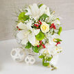 On a clean white table beneath gentle, natural light, an opulent wedding-ready bouquet is displayed against a softly textured beige backdrop, the kind of serene setting you might find in a New Barnet boutique hotel. The arrangement is dominated by crisp white tones and fresh greens, with subtle touches of sunshine-yellow and festive red. Several grand white Oriental lilies open confidently at the centre, their broad, slightly recurved petals showing faint speckles and elegant stamens tipped with pollen. Nestled near them, a single yellow rose, perfectly swirled and creamy, glows like a drop of morning light. Around these statement blooms, clouds of tiny white baby's breath create a misty halo, while rounded, almost spherical tufts of vivid green Green Trick dianthus add a mossy softness you can almost feel under your fingertips. Light green, feathery foliage stretches outward, giving the bouquet a relaxed, organic shape reminiscent of walks through nearby Oakhill Park. Scattered throughout, glossy red hypericum berries catch the eye, bringing a cheerful, jewel-like contrast that hints at holiday celebrations or joyful toasts. On the right-hand side, a graceful waterfall of white Phalaenopsis orchids tumbles elegantly from the main body of the flowers, their smooth, wing-like petals and yellow-tinged centres adding a couture touch. Young green orchid buds and spiky green accents extend the line of the cascade, enhancing the sense of movement. The blooms are gathered into a white woven basket that subtly mirrors the two white wicker spheres placed to the left, unifying the whole composition. This image captures the refined artistry and balance you'd expect from a seasoned New Barnet wedding florist, ideal for couples planning sophisticated ceremonies or intimate receptions nearby.