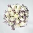 There is an effortless grace to this bouquet, carefully crafted by artisans inspired by New Barnet's calm mornings and blossoming gardens. Elegant white roses lie at its heart, each blossom plush and delicately layered in creamy whorls, symbolising hope and honest affection. Threaded artfully between them are sprigs of pale lavender statice, their lacy textures and gentle purple shades adding visual interest, like the soft haze over King George's Fields at dawn. The subtle green of fresh foliage lends vibrancy, grounding the gentleness of the lighter hues. Set against a clean, whitewashed background and enhanced by soft, natural daylight, every petal appears fresh and luminous, their velvety surfaces inviting to the touch. This bouquet radiates calm and understated celebration, perfect for moments of heartfelt comfort, warm congratulations, or serene memorial tributes-its presence lingers like the faintest floral scent in a sunlit New Barnet room, capturing the community's spirit of peaceful optimism.