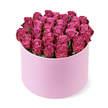 A sumptuous cluster of deep fuchsia and magenta roses forms a rich, rounded crown above a pale pink hat box, the sort of elegant gift you might send to a loved one in New Barnet for an unforgettable occasion. Dozens of roses are packed closely together, their fresh petals arranged in a tight dome that completely conceals the mechanics beneath and slightly overflows the edge of the box, suggesting generosity and abundance. Each bloom shows a gentle gradient of colour: softer pink whorls at the centre, deepening to berry-like magenta at the outer edges, giving the overall arrangement a sense of depth, as if the colour pools and intensifies toward the top. The cylindrical hat box is a delicate pastel blush with a smooth, matte, almost suede-like texture, offering a refined contrast to the organic softness of the petals. Only a whisper of dark green foliage is visible at the base of the heads, a subtle frame that keeps the focus firmly on the roses. Photographed on a crisp white background from a slightly raised angle, the arrangement casts a faint shadow that anchors it while the bright light highlights every curve of the petals and the gentle sheen on the box. As a piece, it feels suited to high-end celebrations: a romantic gesture delivered to a home near New Barnet station, a luxurious centrepiece for an intimate dinner, or a statement floral hat box that turns a simple room into a scene of romance and refined celebration.