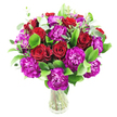 A lush, generously rounded bouquet of deep red roses and magenta-purple carnations sits in a simple clear glass vase, described as if placed on a table in a quiet New Barnet home. The roses range from tight buds to gently unfurling blooms, their velvety spirals catching soft, natural light and suggesting a warm, heady scent of classic romance. Interspersed between them are ruffled carnations in a vivid, almost fuchsia-leaning purple, their frilly, layered petals providing playful texture and a vibrant counterpoint to the roses' smooth surfaces. Bright, glossy greens-likely ruscus or similar foliage-form a dense, verdant backdrop that makes the reds and purples sing, while steely, silvery eucalyptus sprigs lift the composition with slender, aromatic leaves that rustle faintly when moved. The stems are visible through the transparent vase, lending a fresh, honest simplicity to the overall design and grounding the arrangement in natural form. Light falls across the petals to create subtle highlights and shadow, giving depth and motion to the cluster; you can almost imagine the fragrance drifting gently into the room. This bouquet feels celebratory and intimate at once, an ideal choice for anniversaries, Valentine's Day, or to send encouragement and appreciation to someone special in New Barnet. A local florist would note the careful balance of colour, texture, and scale here-each stem chosen and placed to achieve a luxuriant, bountiful silhouette that reads as both elegant table decor and a meaningful gift, available for convenient local delivery around New Barnet and nearby streets such as Station Road.