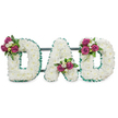 A dignified funeral tribute spelled out in bold capital letters: DAD, each letter formed from a dense, cushiony mass of pristine white chrysanthemums that read like a soft cloud of petals against a stark white backdrop. The blooms are tightly packed to create smooth contours and a voluminous, three-dimensional surface that invites a gentle glance and quiet reflection. A ruffled emerald-green ribbon trims the outer and inner edges of every letter, its crisp pleats providing a cool, structured border that contrasts with the powdery texture of the white florets. Nestled on each letter are three delicate clusters of accent flowers - rich magenta roses in mixed stages of opening, small white freesias or spray blooms adding brightness, and deep green foliage to give the composition depth and architectural rhythm. The first D shows its cluster on the upper left curve, the A carries its bouquet within the lower V, and the final D is graced on the upper right curve, creating a balanced, intentional flow across the piece. A subtle dark green support bar runs behind the letters, barely visible but suggesting the arrangement is freestanding and ready for a chapel, graveside, or service. There is a faint sweet scent of roses and freesia beneath the clean chrysanthemum note; the overall mood is one of reverence, warmth, and personal farewell. As a local New Barnet florist would explain, this kind of bespoke lettering offers a simple, deeply felt way to honour a father - something we create with care for families around New Barnet station, Brunswick Park, and streets such as Station Road and East Barnet Road.
