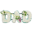 Upright funeral tribute spelling the word DAD in large, block-style floral letters, presented against a bright white background that showcases the careful workmanship of a New Barnet florist. Each letter is completely blanketed with tight clusters of white chrysanthemums or similar small round flowers, placed so closely together that they create a soft, uniform cushion of petals with a gentle, cloudlike texture. Around the edges, a ruffled emerald-green satin ribbon forms a continuous frame, its sheen and folds catching the light and giving each character a sharp outline that would be clearly visible at a distance in a New Barnet funeral venue. A sturdy dark framework with horizontal bars supports the letters from behind, ensuring the tribute stands steady and aligned as a single piece. Thoughtful floral accents add character and depth: the first D bears a small spray of white freesia and lush green foliage on its upper left curve, while the last D carries a similar but slightly more modest arrangement on its top right. Two graceful green stems rise from the first D and sweep diagonally toward the central A, drawing attention to a focal spray nestled on the A itself. Here, two deep purple calla lilies curl elegantly among white freesia and leafy greens, introducing a rich, solemn contrast to the otherwise white and green scheme. The overall impression is of calm, dignified beauty and deep affection, a personal floral message designed to honour a father's memory and offer comfort to family and friends gathered in New Barnet to say goodbye.