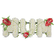 A dignified, three-dimensional sympathy tribute spelling out the word MOM, shown against a plain white backdrop. Each letter is densely covered in hundreds of small, pristine white spray chrysanthemums, their button-like heads packed so closely the surface reads as a soft, cloudlike cushion-quiet, pure, and tactile. A subtle dark green support frame peeks from the edges, giving the freestanding letters structure while remaining unobtrusive. To punctuate the white, three glossy red anthuriums with their pale yellow/white spadices are placed like thoughtful punctuation: one on the upper left curve of the first 'M', a second nestled at the base of the central 'O', and a third crowning the upper right of the final 'M'. Around each anthurium are small sprays of deep green foliage-feathery fern fronds, broader glossy leaves and slender arching blades-that soften the geometry and introduce gentle movement. Thin, grass-like stems drape and link the red blooms across the white letters, visually uniting the piece and guiding the eye along its clean lines. The anthuriums' waxy sheen contrasts with the fine, matte texture of the chrysanthemums, and under soft daylight the composition reads as both reverent and tender. This classic white-and-red arrangement carries a clear emotional tone of love, remembrance and respect, appropriate for a funeral service, wake or graveside tribute. As a local florist in New Barnet, we often prepare this style for families seeking an elegant, comforting expression of grief-simple in palette but rich in meaning, designed to offer quiet solace and dignified remembrance in a difficult time.