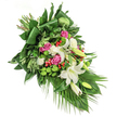 Imagine a tranquil cascade of flowers, lovingly arranged by a New Barnet florist to offer comfort and reflection in moments of farewell. Against a spotless white background, this spray unfurls diagonally, drawing the eye along a graceful passage of colour and form. At its heart, creamy white oriental lilies open in stages-some with their golden-yellow stamens glowing softly, others gently bowed in unopened promise-surrounding the piece with an air of gentle purity and peace. Vibrant pink and fuchsia-hued roses nestle amid the lilies, their unfolding petals carrying the warmth of remembrance and quiet affection, while small white spray carnations weave textural interest into the bouquet, suggesting tender embraces and shared memories. Lime-green, spherical santini chrysanthemums punctuate the greenery with a playful lift-much like the lively bursts of colour seen in springtime across New Barnet's parks-while gleaming clusters of red hypericum berries add depth and joyful energy in subtle contrast. The lush backdrop of foliage-deep green, glossy leaves, some folded into purposeful lines, wreathed with lighter feathery fronds and streaming palm branches-creates richness and gentle movement. Dappled natural light gently brushes over the petals and leaves, enhancing their hues and soft textures. This arrangement, ideal as a sympathy gesture or memorial bouquet, blends traditional elegance with modern vibrancy, embodying a heartfelt tribute rooted in the spirit and care of New Barnet's close-knit community.