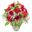 A striking red and white bouquet rests in a clear, slightly flared glass vase, photographed against a pure white background that makes every colour appear vivid, as though waiting to be carried down a New Barnet side street on a special evening. At the centre of the design, deep red roses draw the eye; some are tightly furled buds, others more open, their velvety petals forming graceful spirals that suggest tenderness and devotion. Surrounding them are abundant crimson carnations, with frilled, ruffled petals that create a plush, almost cushion-like effect, giving the piece a generous, full silhouette. Interwoven among these red blooms is a soft haze of white baby's breath, the tiny, star-like blossoms forming gentle clusters that lighten the arrangement visually and bring a sense of purity and calm. Lush green foliage adds depth and contrast: classic dark green rose leaves and rounded eucalyptus stems in muted silver-green tones are thoughtfully placed to frame the flowers and create a natural rhythm throughout the bouquet. The overall shape is a carefully constructed dome, dense yet balanced, offering a traditional, romantic profile that would sit beautifully on a dining table in a New Barnet flat or on a windowsill looking out towards the trees around Victoria Recreation Ground. The glass vase reveals straight, tidy stems immersed in clear water, reinforcing the impression of freshness and professional care. This bouquet's red-and-white palette and classic styling make it perfect for anniversaries, Valentine's Day, or any heartfelt occasion where you wish to express love, gratitude, or quiet celebration within the New Barnet community.
