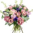 A lush, multi-layered bouquet fills the frame, photographed against a bright white background that allows each flower and leaf to stand out with clarity. The arrangement is rounded and full, dominated by roses in gentle dusty rose and pale peach tones, some opening wide to reveal complex spirals of petals, others still partly closed to give a sense of natural progression. Intermingled with these are generous carnations whose ruffled petals show a beautiful gradient from richer magenta at the very edges to soft blush and cream toward the centres, adding plush texture and visual interest. Deep indigo and violet-blue anemones peek through the softer shades like small jewels, their dark central eyes providing points of contrast that keep the eye moving across the bouquet. Rising slightly above the main cluster are slender stems of lavender and pale pink stock, their many small florets creating a gentle, feathery effect and suggesting a sweet, nostalgic fragrance, much like the scent of flowerbeds near the residential streets of New Barnet in early spring. Encircling the blooms, silvery-green eucalyptus discs blend with darker, glossy foliage to form a rich green halo, cooling the overall palette and giving the design a fresh, garden-picked character. At the base, the natural stems are cleanly gathered into a hand-tied finish, their alignment and varying thickness hinting at the skilled hands that arranged them. The lighting is bright and even, revealing the subtle velvet of the petals and the crisp edges of each leaf. The bouquet feels ideal for thoughtful gifts, romantic gestures, or same-day delivery to homes and offices around New Barnet, bringing a note of elegant tranquillity to everyday life.