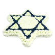 A large Star of David funeral tribute, crafted from tightly clustered white and deep navy chrysanthemums, dominates a spotless white background, making its symbolic form instantly clear. The six-pointed Magen David is built from countless small blooms arranged so closely together that they form a smooth, plush surface, almost like a soft quilt of petals. A broad, defined border of white flowers runs around the outer edges of the star, while the central hexagon and the six triangular segments that point inward are also fully filled with cool, luminous white blossoms, bringing a sense of light and purity to the heart of the design. In contrast, the two overlapping triangles that create the familiar Jewish emblem are made entirely from dense navy blue flowers, their deep tone cutting bold, straight lines through the surrounding white. This interplay of dark blue and white recalls the colours of the Israeli flag and underscores the tribute's strong connection to Jewish identity, faith, and remembrance. Subtle shading at the petal edges suggests gentle overhead lighting, giving the arrangement a touch of three-dimensional depth, as if it were resting quietly on a stand in a chapel or funeral home in New Barnet. The overall impression is one of precise craftsmanship and heartfelt intention, suitable for Jewish funerals, shiva gatherings, or memorial events held across New Barnet and nearby areas such as High Barnet or East Barnet. The piece offers a dignified, comforting expression of sympathy and enduring tradition for families marking a life well lived.