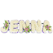 A tender, hand-crafted memorial spells the name JENNA in bold, three-dimensional block letters formed of dense, creamy-white chrysanthemums that read like a soft, fragrant cloud against a pristine white backdrop. Each letter has been carefully built to hold its shape, the tiny petals packed so closely they create a comforting, plush surface that almost mutes sound - a quiet texture suited to reflection. A narrow band of deep purple ribbon or tiny lavender blooms traces the inner edges and base of each letter, lending definition and a gentle, respectful contrast to the white composition. Small, artful clusters of spray roses in blush-pink and pale lavender are tucked into three key points - the curving top of the J, the base of the second N, and the outer sweep of the final A - accompanied by soft cream or pale yellow roselets that add a whisper of warmth. Delicate dark-green fern fronds nestle these clusters, introducing a cool, slightly sweet green scent and a feathery texture against the rounded chrysanthemum heads. Fine, dark support bars hold the letters in a graceful horizontal line, visible only as a subtle structural element that keeps the piece cohesive and dignified. Soft studio light skims the surface, picking out petal edges and the satin gleam of the purple trim, creating a calm mood of remembrance. This bespoke floral name tribute reads as a profoundly personal sympathy tribute or funeral feature, a tactile and scented marker of love that would be fitting for a memorial near New Barnet station or a service in the local Brunswick Park community - a gentle, crafted farewell that honours a name with care and quiet beauty.