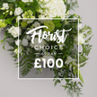 A pristine Florist Choice Spray stands out against a soft grey background, richly described through white hydrangeas dominating the center and upper side with dense clusters, complemented by white roses in multiple stages of bloom. Lisianthus type blooms with bell-like shapes and faint green accents populate the left and lower right, while an abundant green backbone-feathery ferns, grey-green eucalyptus, and dark ruscus leaves-provides textural depth. The arrangement is gently framed by a thin white border that holds a central information panel: Florist Choice in a flowing script, SPRAY in bold uppercase, and the price £100 at the bottom, with light transparency to allow the greenery to glow softly through. This elegant, premium spray conveys a sense of calm refinement, suitable for memorials, thoughtful gifts, or elegant occasions. Crafted by Flowers New Barnet and offered for delivery across New Barnet and nearby areas, it embodies local expertise, freshness, and the art of timeless floristry.