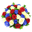 A vibrant, tightly gathered bouquet of roses in deep red, pure white, and brilliant cobalt blue fills the entire frame, creating a bold, patriotic statement against a pristine white studio background. The roses are arranged in a smooth, domed shape, with roughly three dozen blooms tucked together so closely that their petals almost touch, forming a rich, textured surface. Each flower has opened fully, revealing lush spirals of velvety petals that curl outward in soft, layered waves, some edges gently ruffled as if just beginning to relax. The red roses are intense and romantic, the white roses are clean and luminous, and the blue roses add a striking, contemporary note that feels both celebratory and symbolic. Dark green foliage is threaded between the blossoms, its glossy leaves adding a natural frame and helping to define the round silhouette of the design. Bright, even lighting bathes the bouquet, much like crisp daylight over New Barnet's station and nearby park, throwing subtle highlights onto the petals and casting delicate shadows that give the arrangement depth. The absence of a visible vase focuses attention entirely on the flowers, making the colours appear almost to float in space. This is the sort of bouquet you might see prepared by a skilled local florist for a remembrance service, a national celebration, or a special family gathering in New Barnet or along nearby High Barnet's bustling streets. It carries an air of pride and togetherness, while still offering the intimate charm and fragrance of freshly cut roses chosen with care.