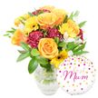 A cheerful, gift-ready bouquet set captured against a clean white backdrop: a clear glass vase cradles a lush grouping of warm-toned blooms whose stems are visible through the water, suggesting fresh-from-the-market care. The composition is dominated by large, fully opened roses in radiant orange and sunlit yellow, their velvety petals unfolding in soft spirals. Bright yellow gerbera daisies punctuate the arrangement like small suns, their flat faces and deep brown centers offering a lively, graphic contrast. Deeper maroon or burgundy carnations, ruffled and plush, tuck into the mid-layer to add depth and a velvety texture that anchors the palette. Scattered among these are delicate white alstroemeria - slender-petalled Peruvian lilies with subtle speckling - that lift the bouquet with an airy, elegant note. A generous cloud of varied green foliage, from glossy broad leaves to fine, feathery sprigs, frames the flowers and gives the arrangement a freshly gathered, garden-sprung feel. To the lower right, slightly overlapping the vase, a round white foil balloon sits playfully; it is dotted with gold and hot-pink confetti-like polka dots and tiny heart motifs, and carries the flowing hot-pink script message best Mum. The overall impression is one of warm celebration-fragrant rose perfume softened by the faint, green scent of cut foliage-perfect for a Mother's Day or birthday surprise. As a local touch, this style of arrangement is the sort of cheerful gift many customers request for delivery around New Barnet station and Brunswick Park, where bright seasonal flowers are especially appreciated.